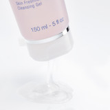  Bottom portion of the tube showing the volume "150 ml - 5 fl oz" text and silver cap detail with reflection.