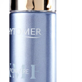 A close-up view of a blue Phytomer Pionnière cosmetic bottle showing the brand name and product line in white text.