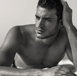 Black and white portrait of man with hand in hair looking contemplatively to the side. Black and white portrait of man with hand in hair looking contemplatively to the side.