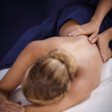 Person receiving a therapeutic back massage from a professional massage therapist.