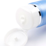 White pump dispenser cap on blue skincare bottle.