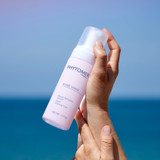 A woman holding a Rosee Visage Cleansing Foam bottle.