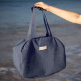 Woman holding a Phytomer Weekend Bag at the beach.