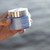 Someone holding the Hydra Original Moisturizing Melting Cream at the beach