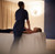 Massage therapist performing a treatment on a client lying on a massage table in a softly lit spa room with curtains.