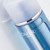 Phytomer skincare bottle with white cap containing blue liquid and visible water droplets on the glass surface.