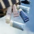 Travel size Rosee Visage Toner,  Travel Rosee Visage Gel, Travel Oligomer Well-Being Body Cream, Travel Sublime Night Balm, and Travel Expert Youth Cream spilling out of the striped cosmetic pouch.