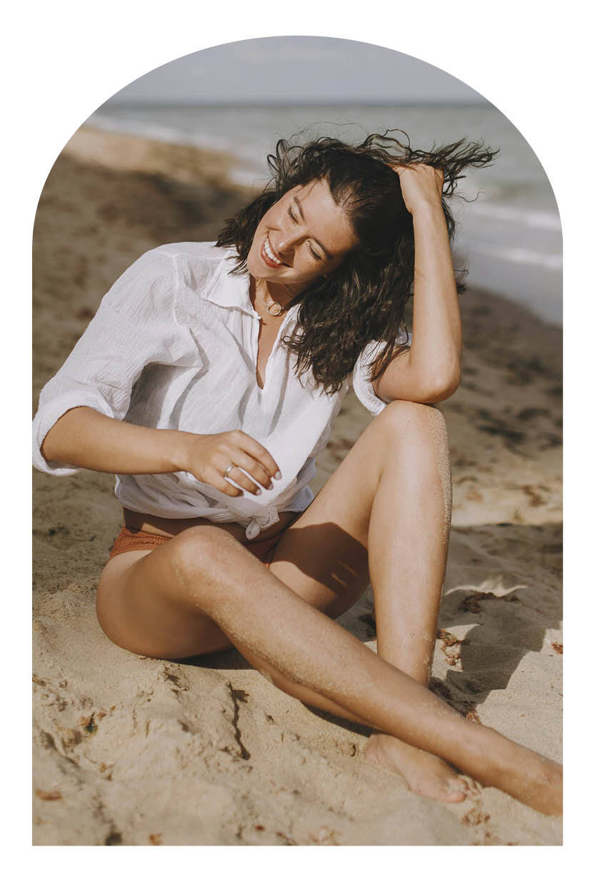 Woman running her hands through her hair at the beach.