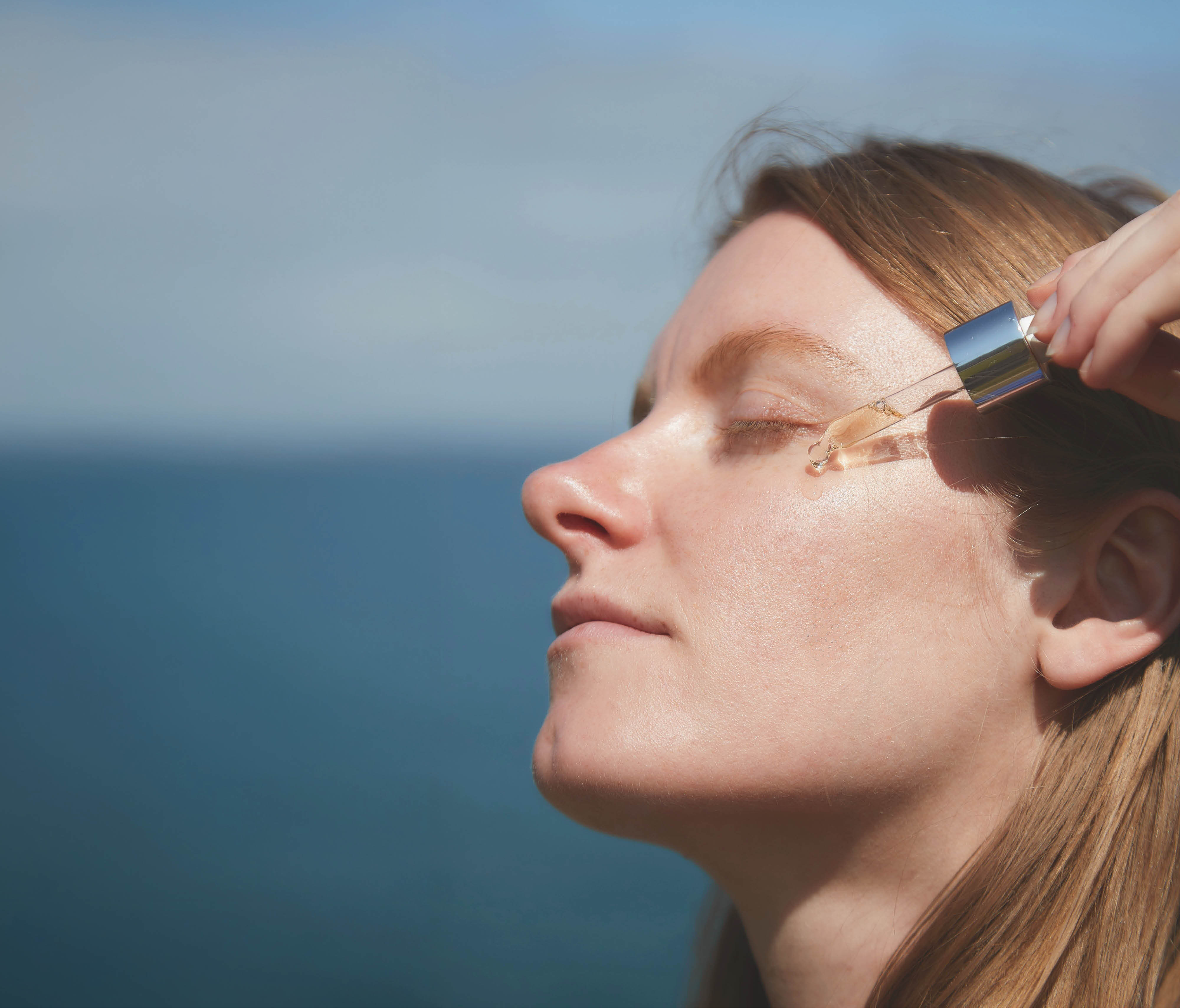 Woman applying the Oligoperformance Serum to her skin.