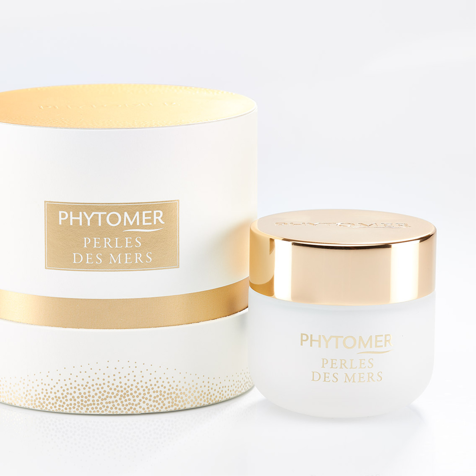 Phytomer Perles des Mers cream jar with gold lid next to white and gold cylindrical gift box