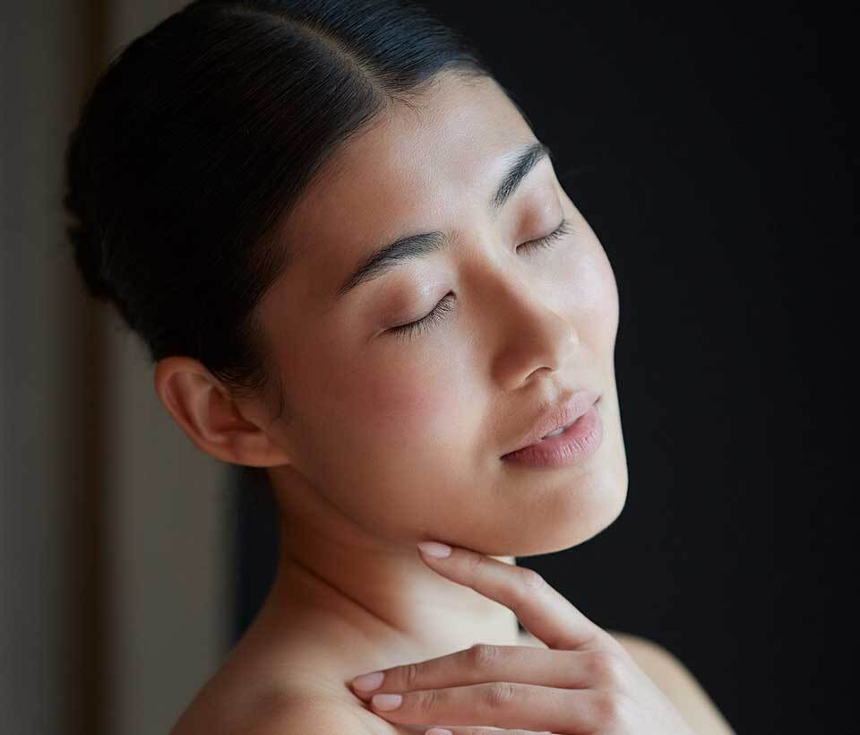 Asian woman caressing her face after a Phytomer facial..