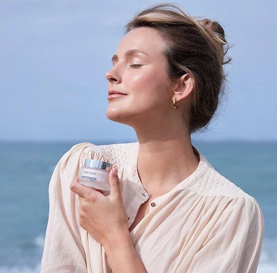 Woman holding the Rosee Glow Vitamin Radiance Plumping Cream close to her chest.