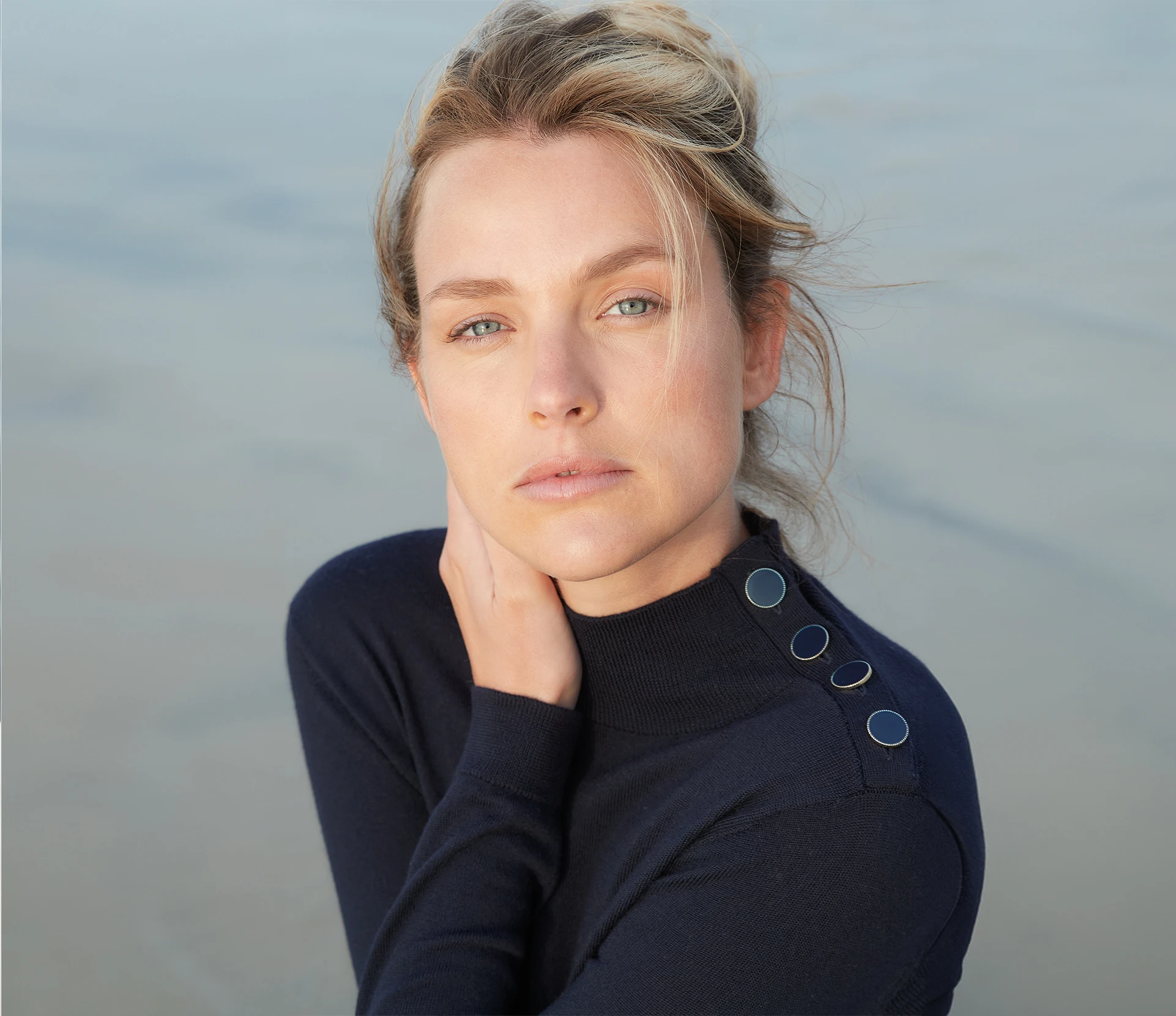 Woman in a turtleneck sweater, gazing at the camera.