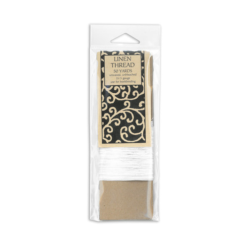 A spool of thread wrapped around brown cardboard in a plastic hang tag package.