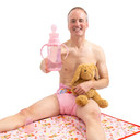 Male model holding Pink Easy Grip Rearz bottle and stuffed animal while sitting on Purrfection change pad and wearing Purrfection diaper.