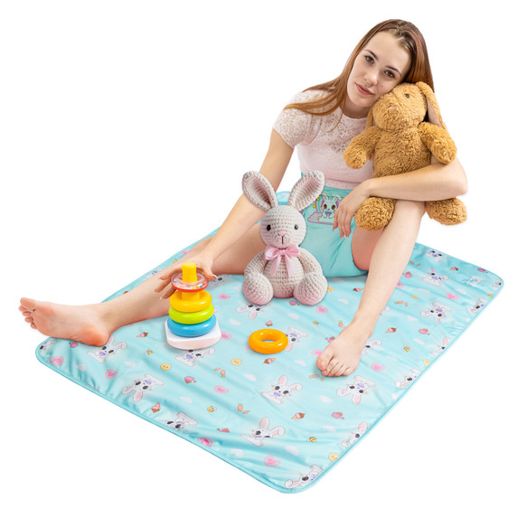 Female model sitting on change pad with toys and stuffed animals.
