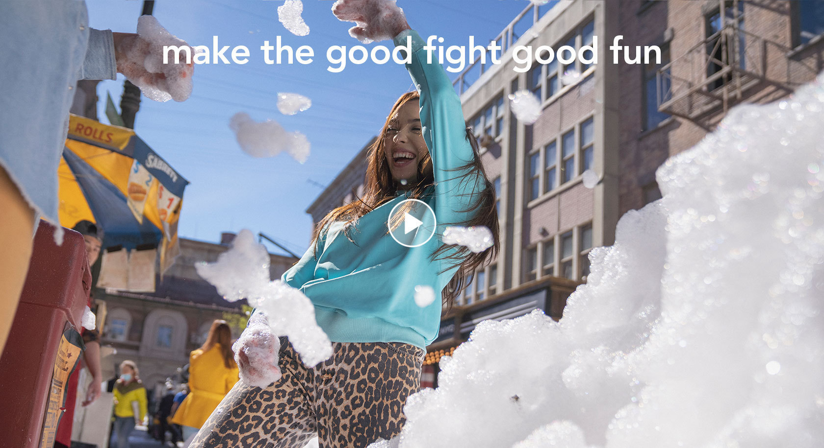 Girl in turquoise sweater standing in the street full of bubbles