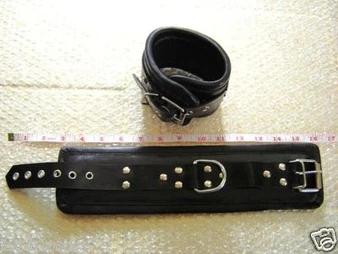 Schwarze Lederfesseln mit Metallnieten und Schnallen, flach ausgelegt