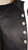 Stoffdetail der schwarzen Jacquardjacke mit dezentem Paisleyrelief und Metallknöpfen.