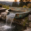 Copper Wall-Mount Water Bowl water flowing into a  pond