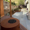 Isla round propane fire pit table with hidden tank enclosure. Shown with the corten steel natural rust steel finish. 