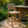 ZUO MODERN Zuo Corde Barstool Beige, outdoor woven rattan barstool with wooden frame and backrest, placed on garden patio with lush greenery.