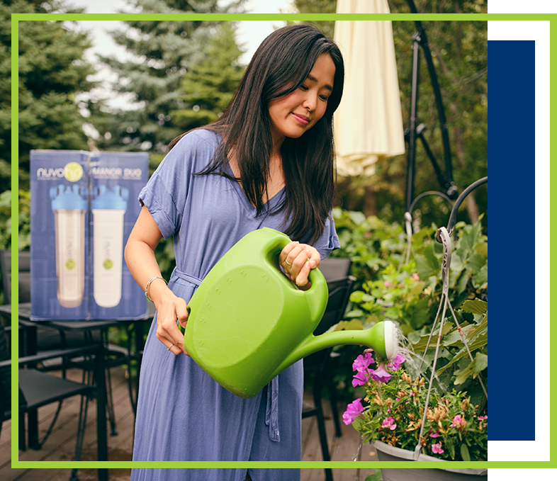 a woman watering plants outside