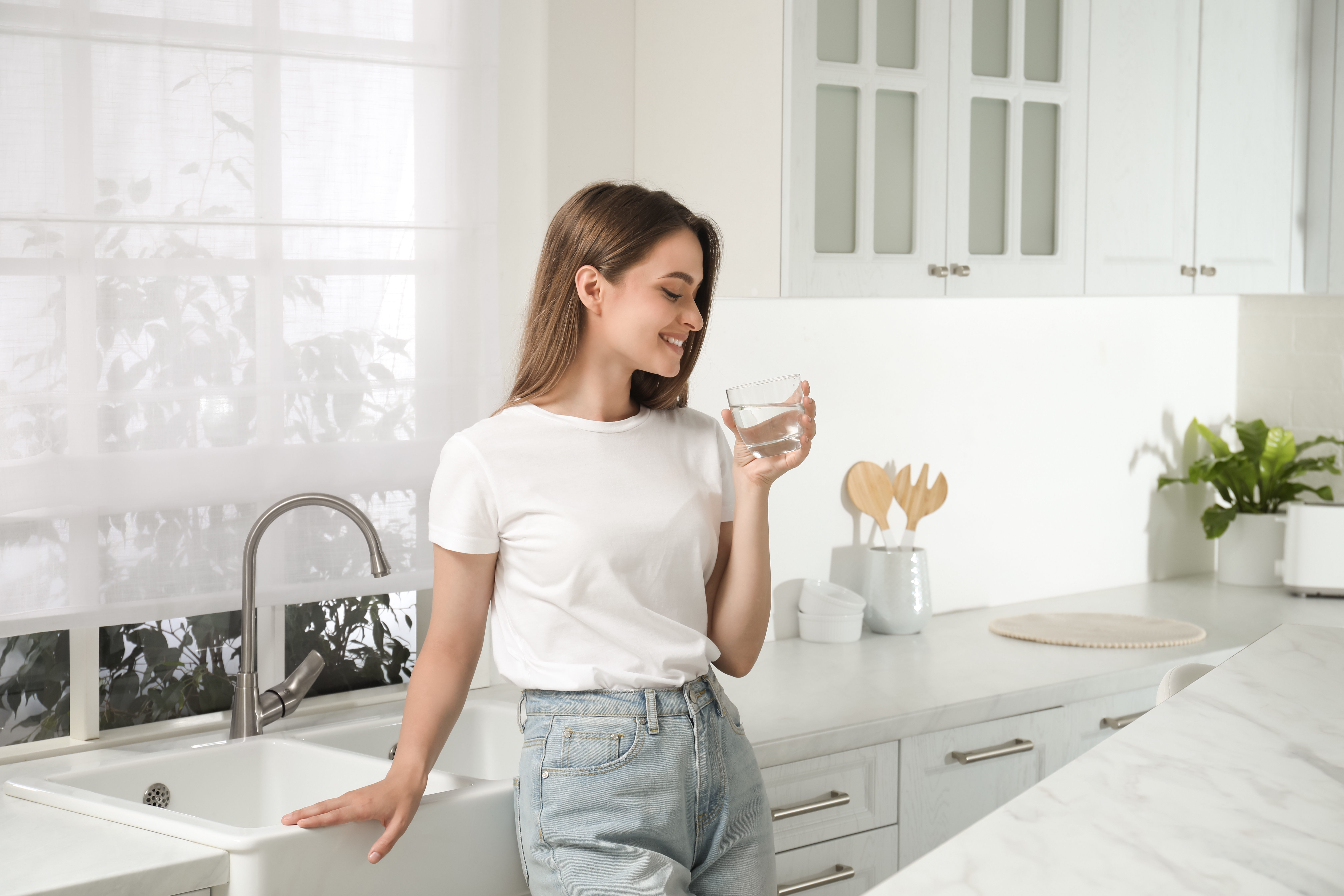 Woman drinking water in kitchen