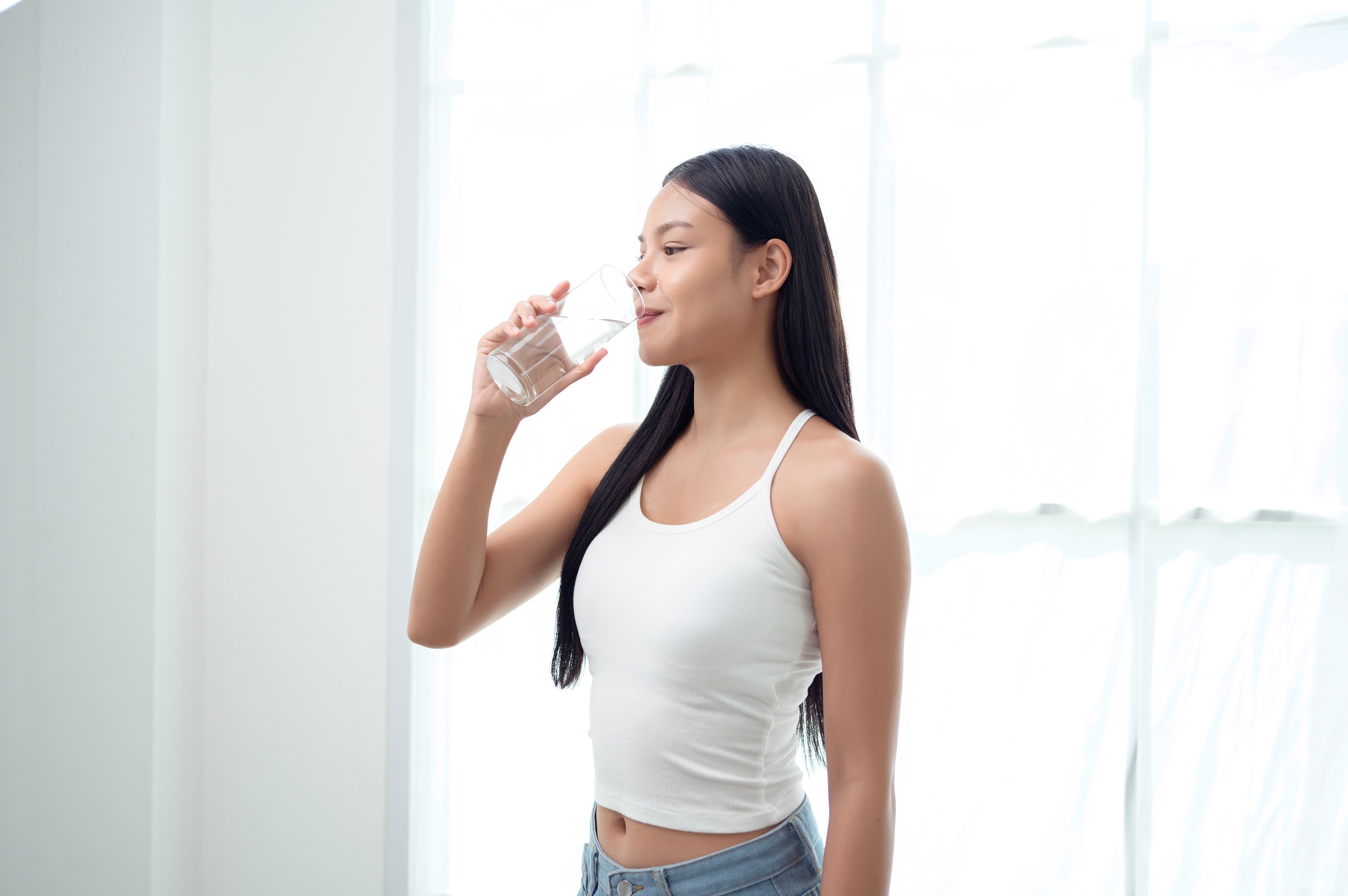 Woman drinking water in sunlight