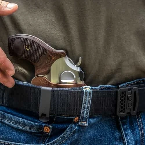 Tulster RATH IWB holster carrying a snub-nose revolver with wood grips, shirt lifted to show the concealed carry position.