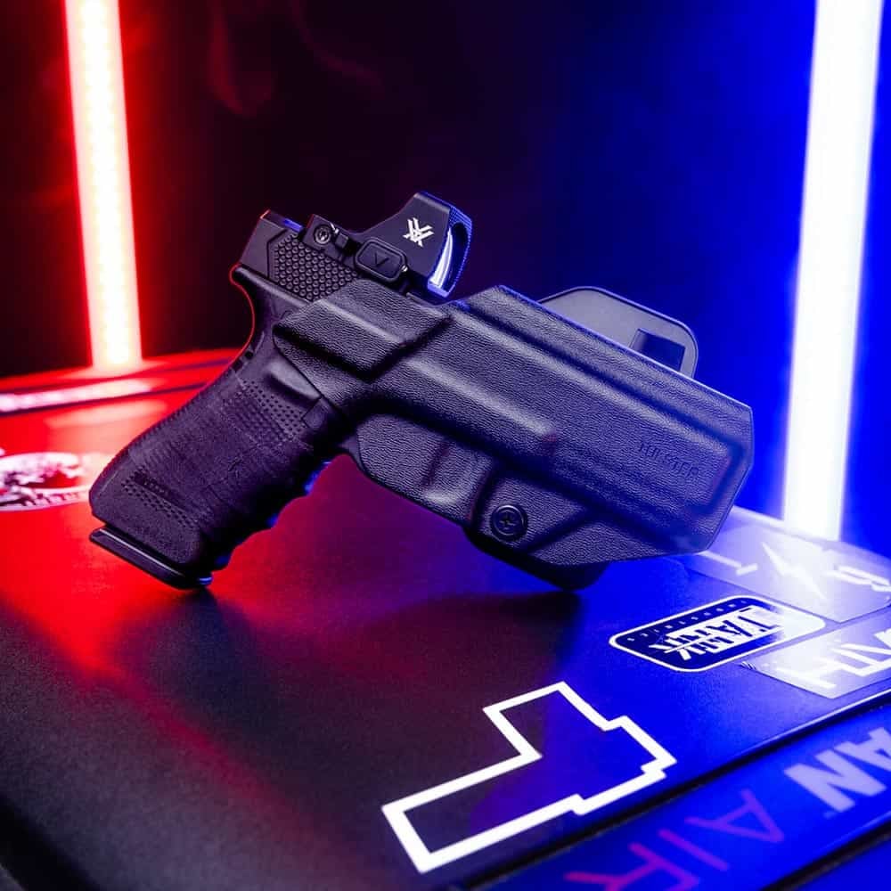 A Glock with a Vortex optic inside of a Range+ outside the waistband (OWB) paddle holster.