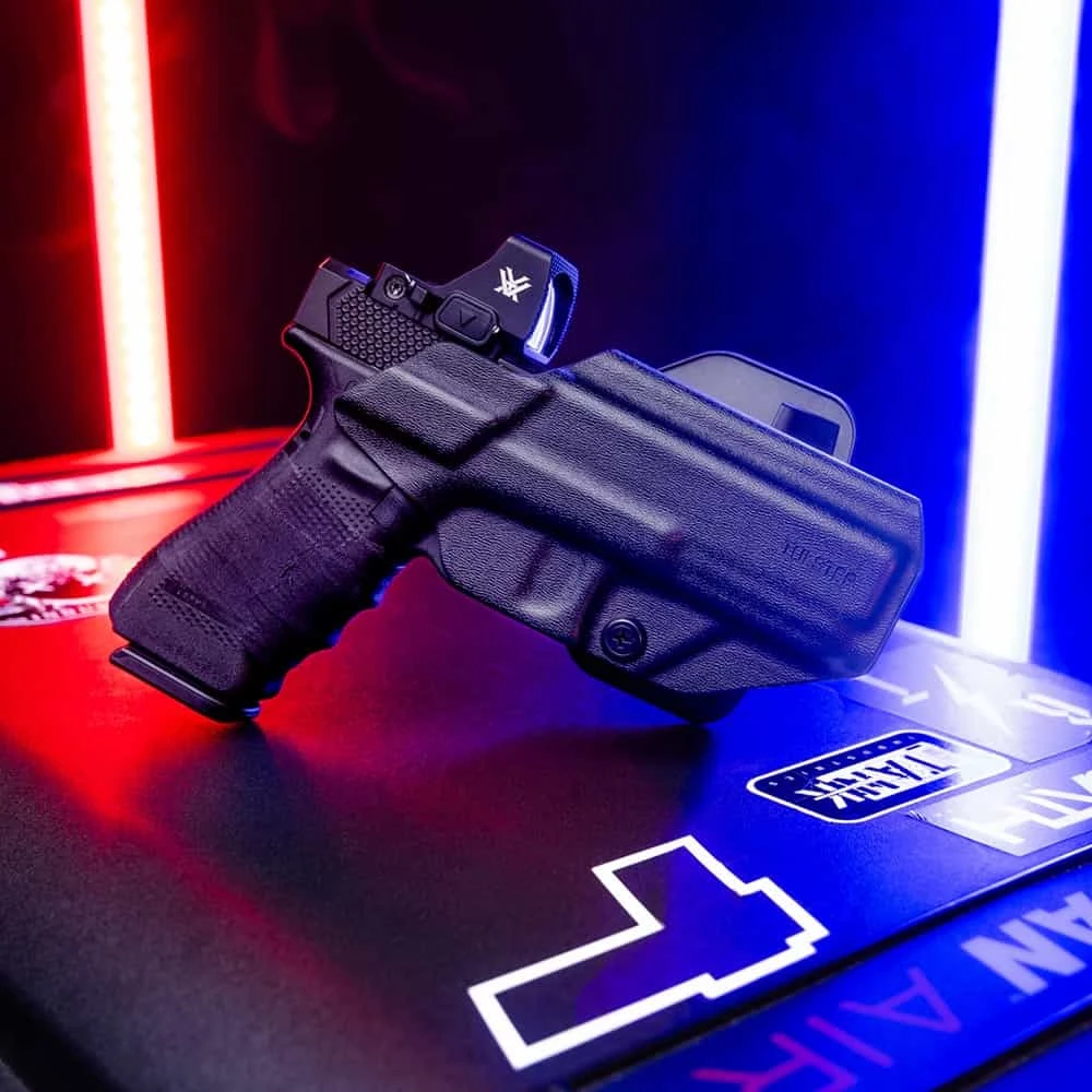 A Glock with a Vortex optic inside of a Range+ outside the waistband (OWB) paddle holster.