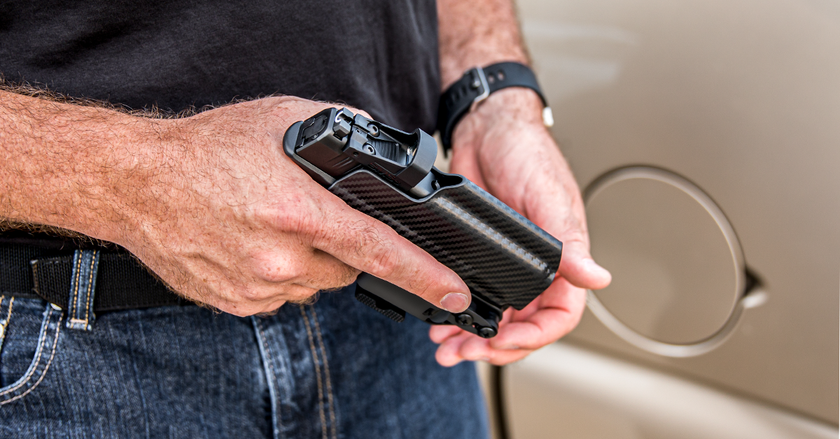 holding handgun near car