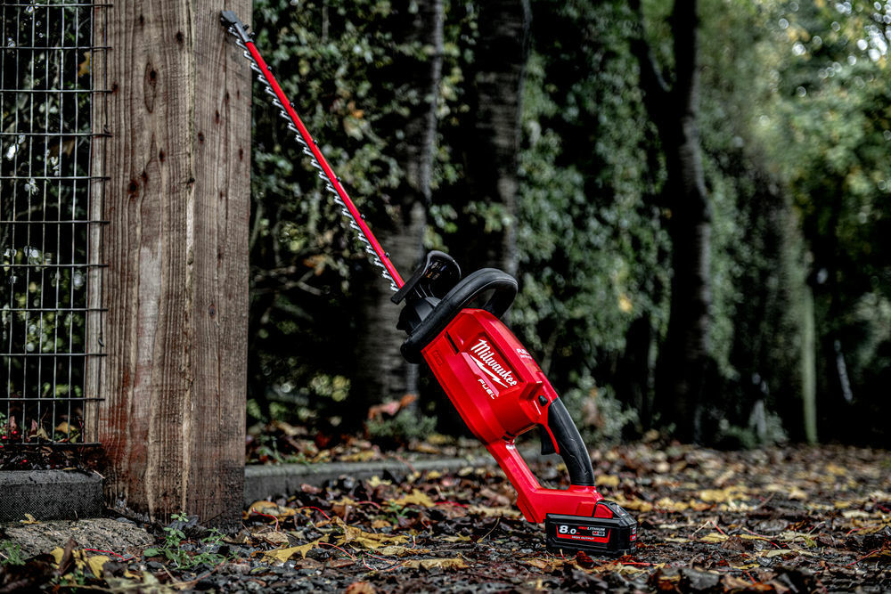 hedge cutter sitting against tree