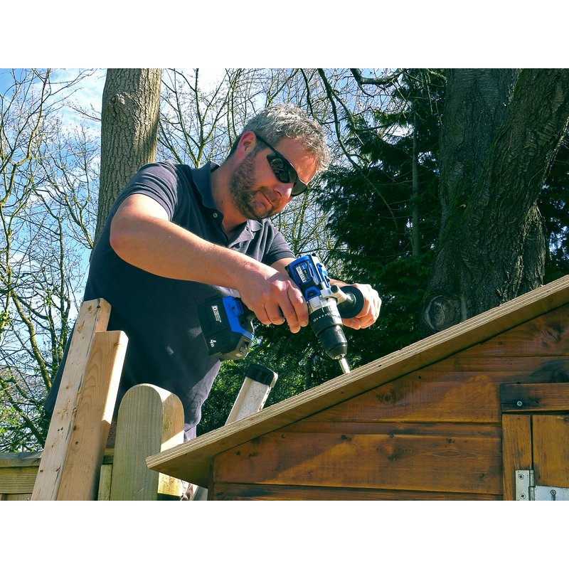 Man uses draper drill to drill a hole in the the roof of a garden shed.
