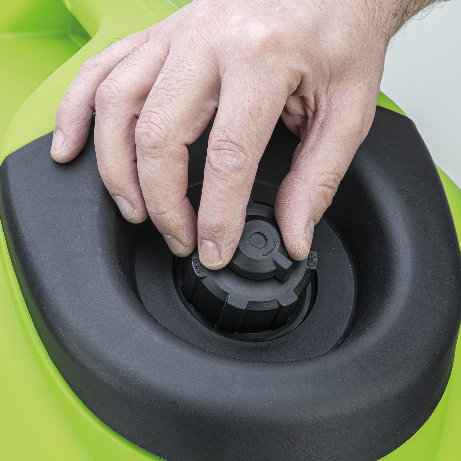Close-up of a hand turning the top fuel cap on the 6-liter petrol tank