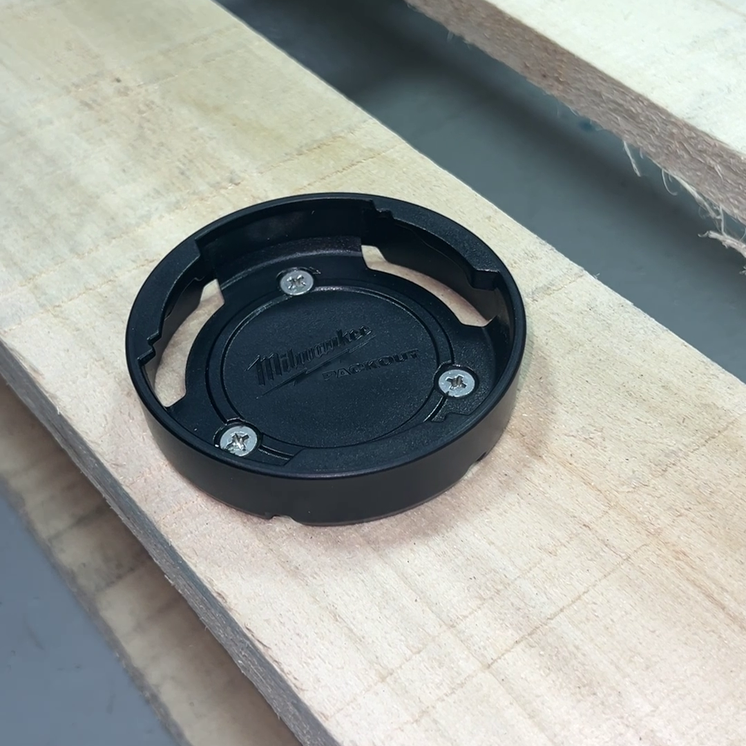 Close-up of the Milwaukee Packout Mounting Puck resting on a wooden pallet