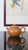 Handcrafted Osmanthus Pear Zisha teapot shot against elegant traditional Chinese scroll painting background, showing delicate golden speckled clay texture.