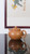 Handcrafted Osmanthus Pear Zisha teapot shot against elegant traditional Chinese scroll painting background, showing delicate golden speckled clay texture.