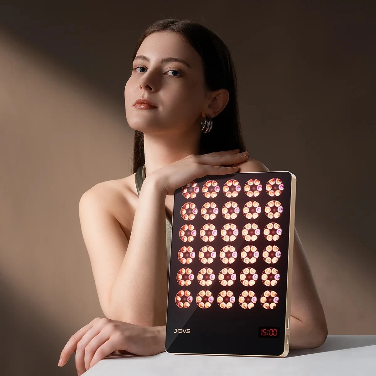 Woman using JOVS Wireless Light Therapy Panel