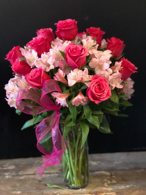 Oh my my!!  A full dozen premium hot pink roses surrounded with long lasting pink alstromeria and garnished with a pink heart shaped bow.  She'll fall in love all over again!