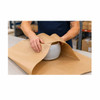 Worker wrapping a product with recycled natural kraft paper for shipping protection
