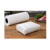 Food package fully wrapped in white butcher paper beside a large butcher paper roll