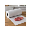White freezer paper roll unrolled on a wooden work surface with a raw steak ready for wrapping