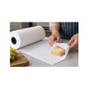 Person wrapping a block of cheese with white freezer paper from a large roll
