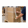 Worker applying 3/4" Bi-Directional filament strapping tape to seal and reinforce a cardboard shipping box