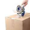 Clear hot melt carton sealing tape applied to a cardboard box with a handheld tape dispenser