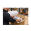 Warehouse worker placing a bubble-wrapped product into a cardboard shipping box