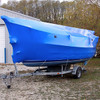 Boat wrapped in blue marine shrink wrap for winter storage and protection from weather, moisture, and debris
