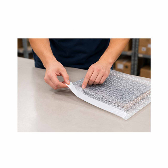 Worker removing adhesive liner from a self-seal bubble pouch to secure an electronic device